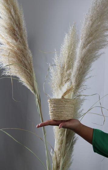 panier en feuille de palmier posé sur une main artisanat marocain